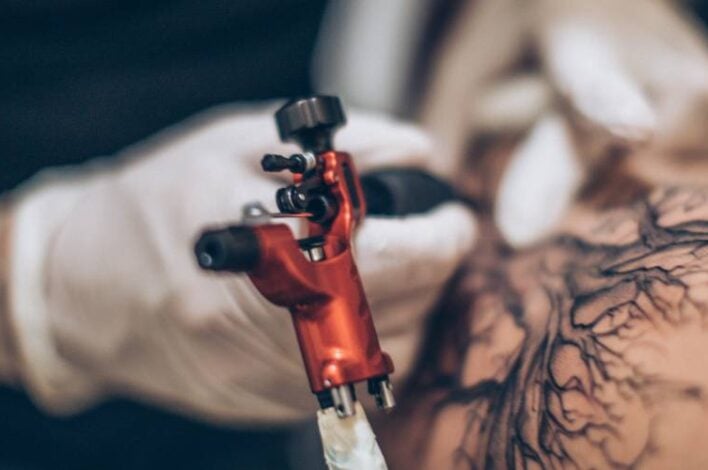 Person getting tattooed by tattoo artist
